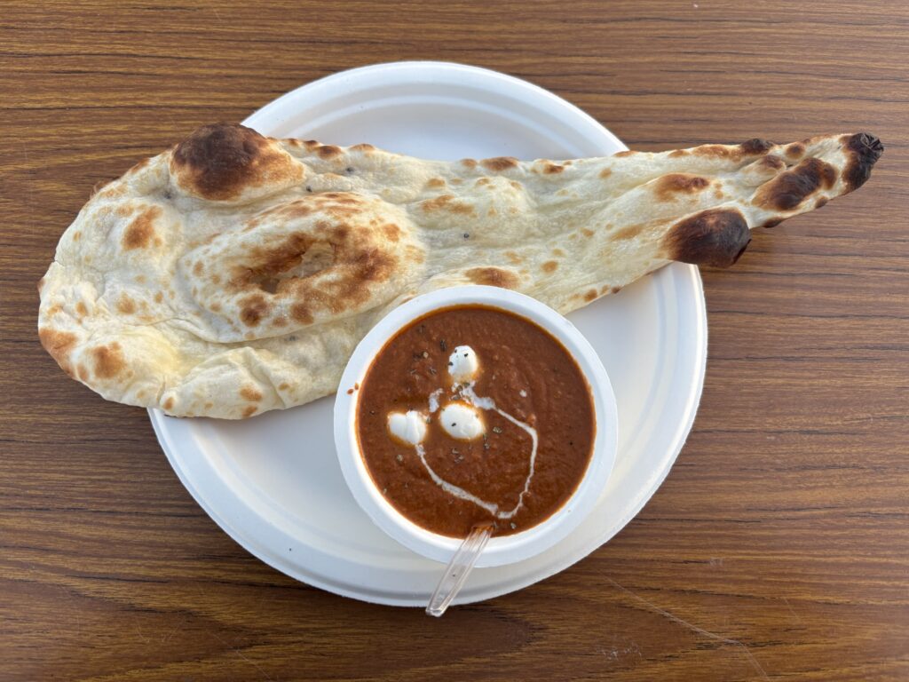 チーズEXPOで販売されていたモッツァレラチーズ入りバターチキンカレーと焼きたてナンのセット写真