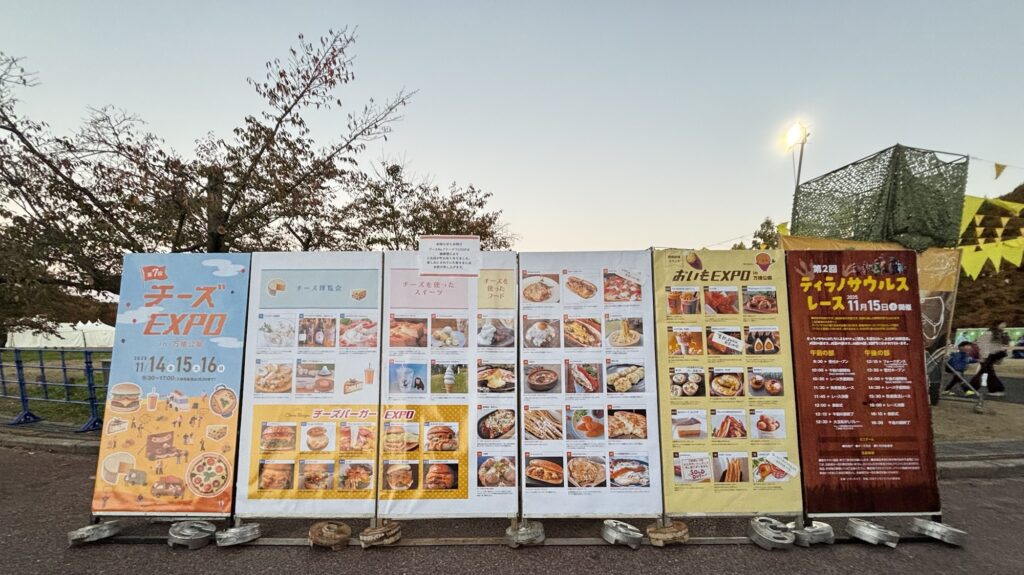 チーズEXPO2025の会場入口に並ぶメニュー看板とイベント案内の写真
