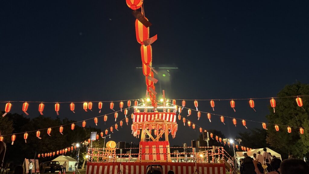 すいたフェスタの夜、赤い提灯に囲まれライトアップされたお祭りのやぐら