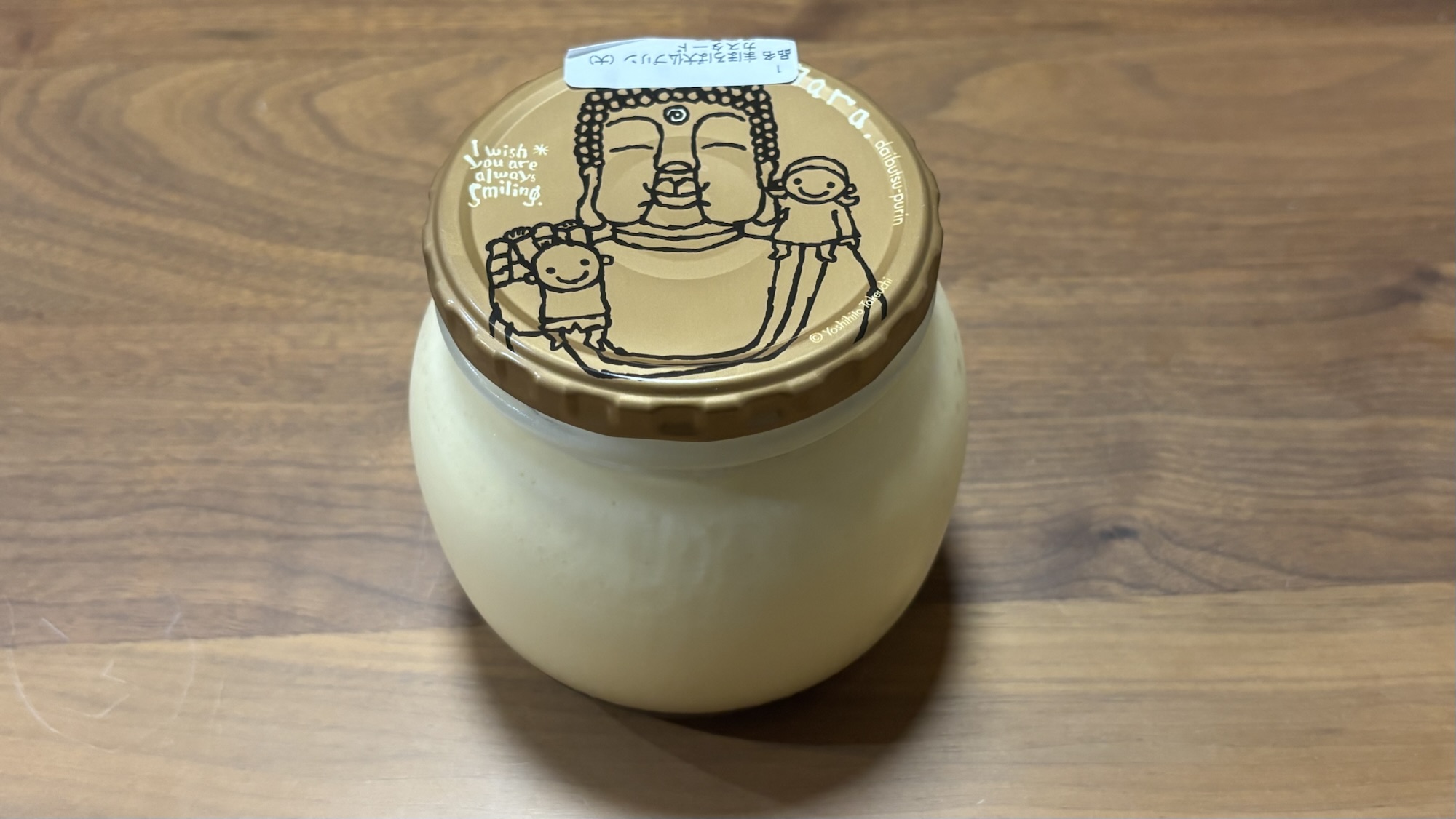まほろば大仏プリン（大）の瓶と大仏さまのイラスト入りフタが写っている写真