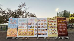 チーズEXPO2025の会場入口に並ぶメニュー看板とイベント案内の写真