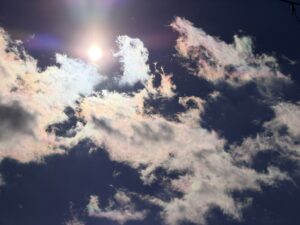 空にうっすらと虹色に染まった彩雲の写真