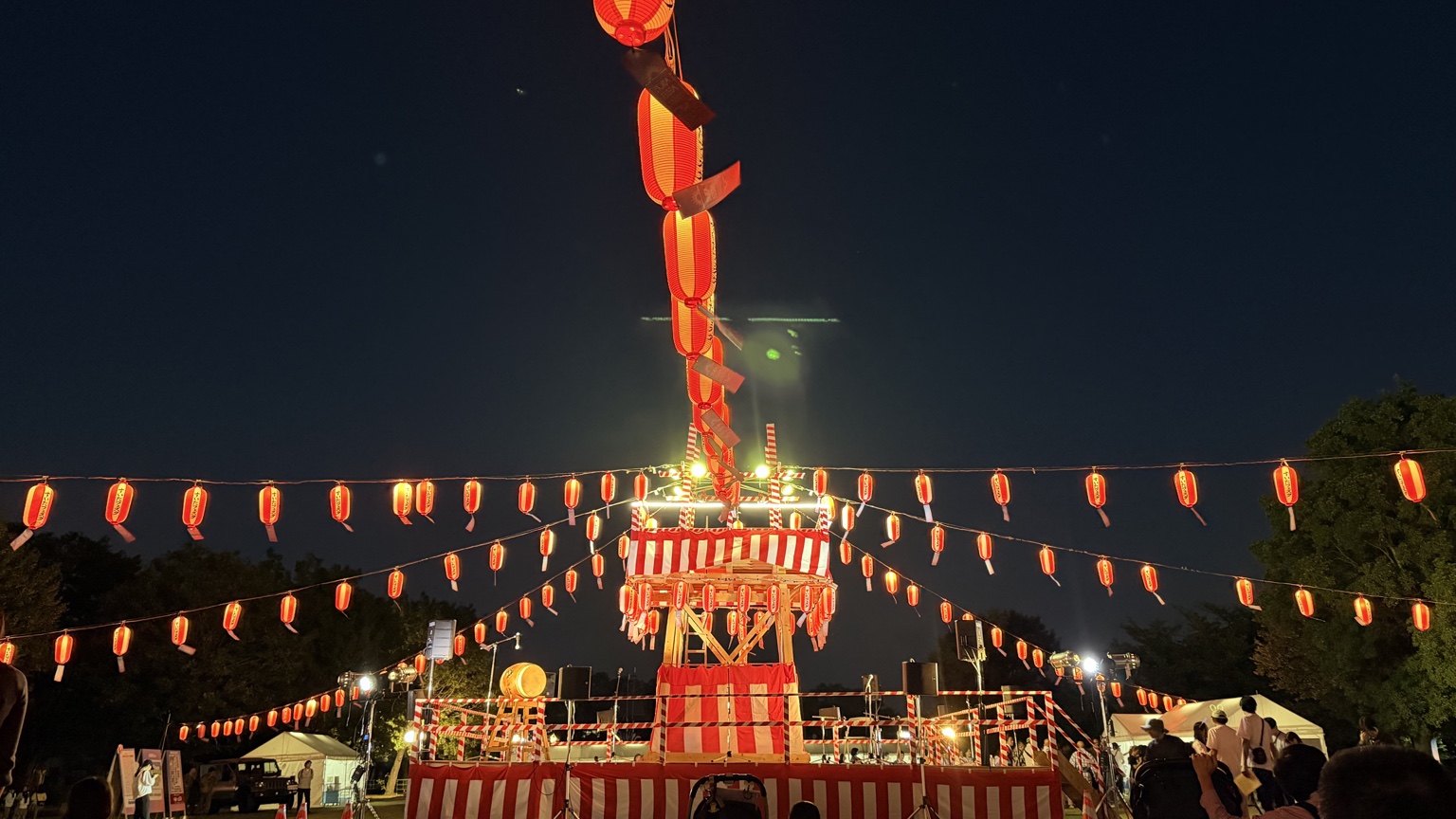 すいたフェスタの夜、赤い提灯に囲まれライトアップされたお祭りのやぐら
